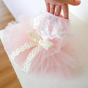 Detailed view of pink multilayer tulle pet dress with white lace embroidery and bow