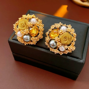 Détails de boucles d'oreilles vintage fleurs avec perles et cristaux sur boîte à bijoux