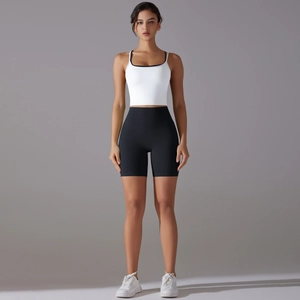 Detailed full-body shot of white sports camisole and black high-waisted gym shorts