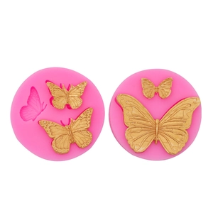 Pink silicone butterfly molds for fondant and chocolate cake decorating on white background