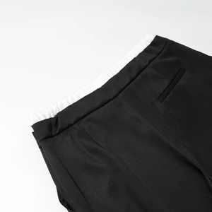 Detail der High-Waist-Hose mit weitem Bein und weißem Kontrast-Gummibund am Saum