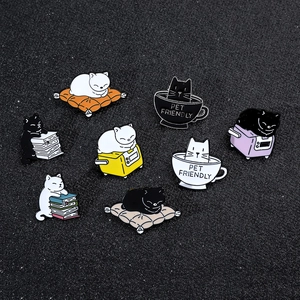 Macro detail of nine cartoon cat enamel pins in various poses on a dark textured surface