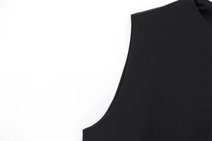Close-up of stitching and fabric texture on a sleeveless black faux fur dress with belt