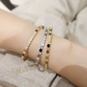 Macro detail of honeycomb bangles in gold and silver finish with sparkling pavé crystals