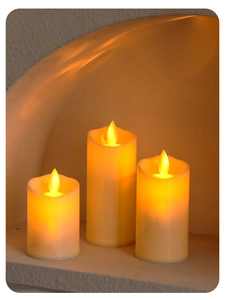 Set van drie vlamloze LED-kaarsen in ivoor met warm oranje licht in een sfeervolle nis