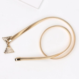 Détail d'une ceinture chaîne dorée élastique avec boucle en métal texturé triangulaire