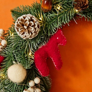 Moon-shaped Christmas wreath with LED lights, red horse ornament and pine cones