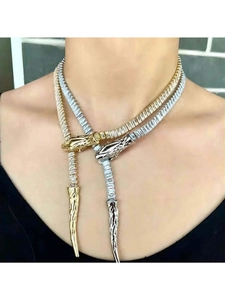 Detailed view of silver and gold serpent necklaces with zircon inlays on model neck