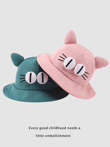 Detail of pink and green cotton toddler bucket hats with 3D cat ears and eye embroidery