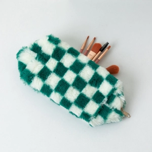 Dettaglio della trousse in peluche a scacchi verdi e bianchi con pennelli da trucco