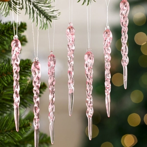Detail of pink transparent spiral icicle ornament hanging on a Christmas tree branch