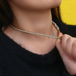 Détail du collier tennis doré orné de zircons carrés porté par un mannequin réel