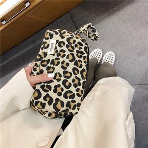 Détail de la trousse de toilette léopard avec poignée solide et fermeture à glissière
