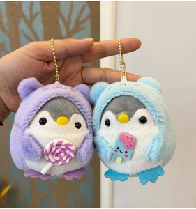 Detail of plush penguin keychains in purple and blue hoodies with cute accessories
