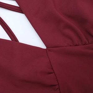 Macro detail of wine red knitted dress showing criss-cross back straps and seam texture