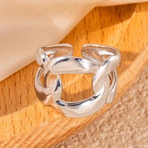Macro shot of silver link chain stainless steel ring on wooden tray with silk cloth