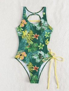 Flat lay of tropical floral monokini featuring backless design and yellow side ties