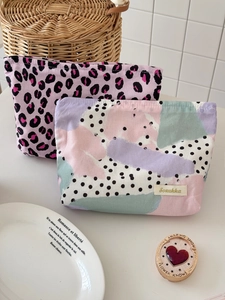 Large capacity leopard print and abstract dot makeup bags on a white vanity desk