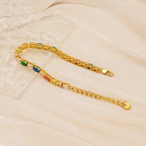 Gros plan d'un bracelet de tennis en acier doré orné de pierres précieuses multicolores