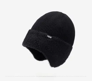 Détail d'un bonnet en tricot noir avec doublure en peluche douce et étiquette de marque FBXS