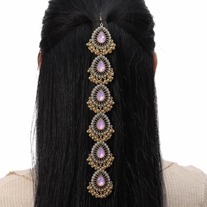 Catena per capelli boho dorata con cristalli rosa su capelli neri vista da dietro
