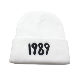 White knit beanie with black 1989 embroidery on the folded cuff, minimalist style