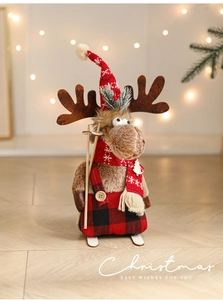 Detailed view of plush Christmas reindeer figurine with red plaid trousers and ski gear