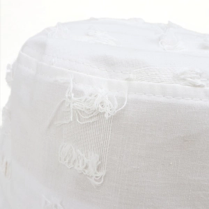 Gros plan détaillé sur le tissu en coton blanc effiloché et les coutures d'un chapeau
