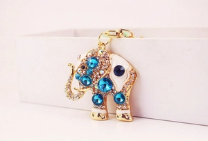 Detailed close-up of golden elephant keychain featuring blue rhinestones and white enamel