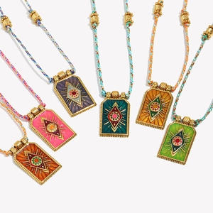Detailed view of colorful enamel eye pendants with woven cords in diverse vibrant colors