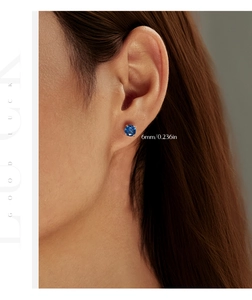 Close-up of a 6mm royal blue octagon cut silver stud earring worn on a model's earlobe