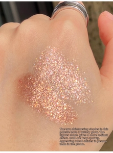 Macro shot of shimmering champagne gold eyeshadow swatches on skin with glitter finish