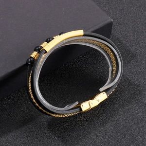Detail of multi-layer black braided leather bracelet with gold magnetic metal clasp