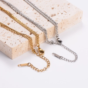 Minimalist gold and silver layered necklaces displayed on natural stone background