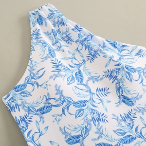 Detail view of the asymmetric one-shoulder design with blue tropical leaf prints