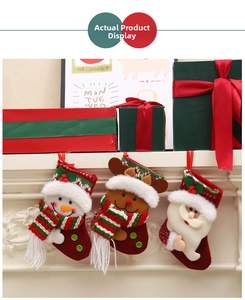Three festive Christmas stockings with Santa, snowman and reindeer hanging on a white fireplace