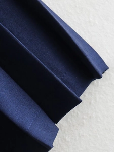 Makro-Detail von dunkelblauem Plissee-Stoff mit feiner Twill-Textur und Nähten