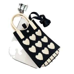Close-up of knitted phone bag with heart pattern and removable black shoulder strap