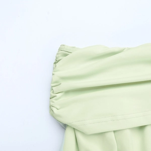 Détail de la robe vert clair à épaules dénudées montrant la texture froncée et la couture