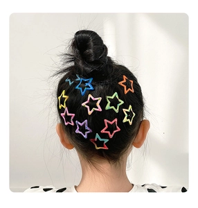 Gros plan de barrettes colorées en forme d'étoile creuse sur un chignon haut de fille