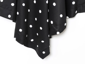 Detailed view of black and white polka dot fabric with high-quality hemmed finish