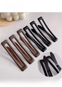 Gros plan de barrettes rectangulaires évidées à texture mate en marron et noir