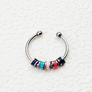 Detail of anxiety ring with five colorful movable beads on a stainless steel open band