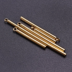 Close-up of golden stainless steel cylindrical bar pendants for DIY jewelry necklaces