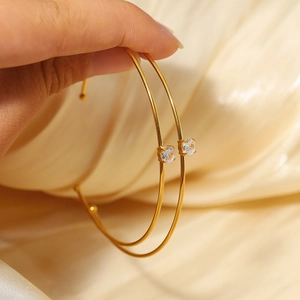 Detail of two 18k gold plated titanium steel bracelets with sparkling moissanite stones