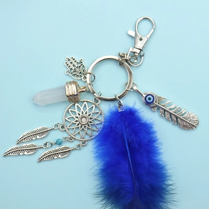 Detailed close-up of a dreamcatcher keychain with blue feather and Fatima hand charms