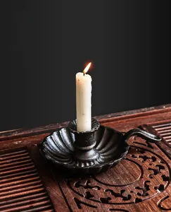 Detail of vintage cast iron candle holder with handle and textured petal base