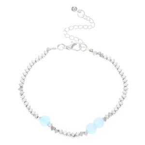 Close-up of silver geometric beads and light blue translucent charms on the delicate bracelet