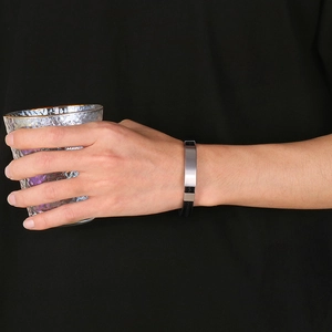 Close-up of minimalist black leather braided bracelet with silver metal plate on male wrist