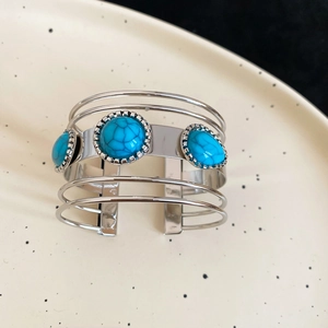 Close-up of bohemian silver layered cuff bracelet with turquoise stones on ceramic tray
